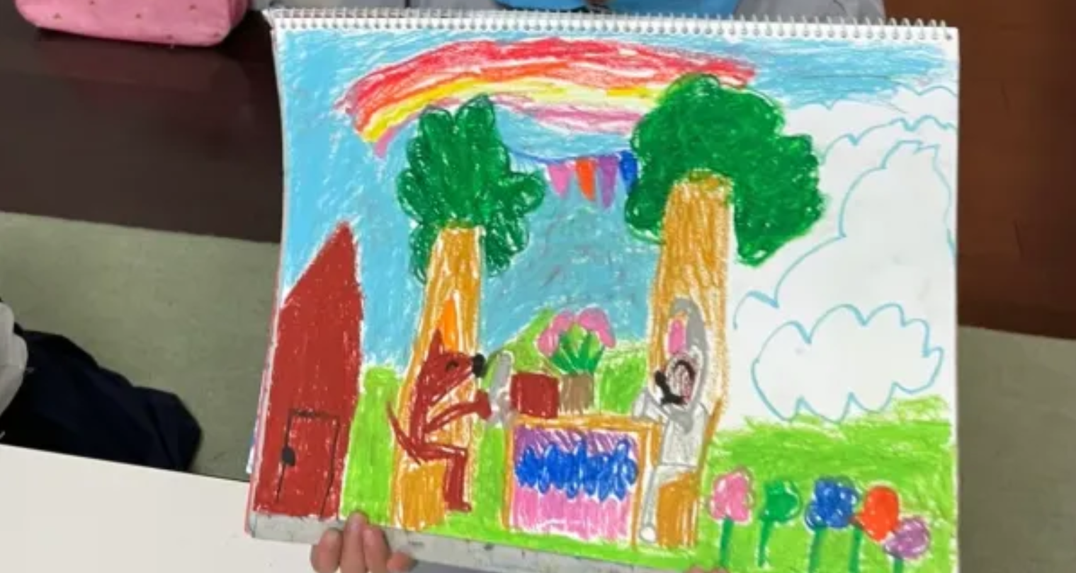 子どもが自分の描いた絵を見せながら発表している様子
